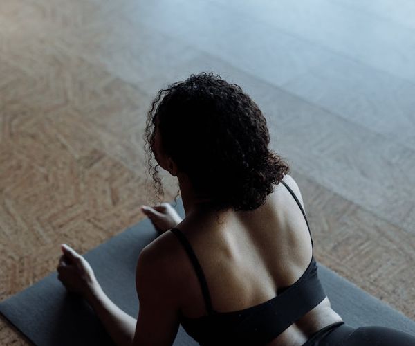 A simple yoga mat and resistance bands on a dark floor.